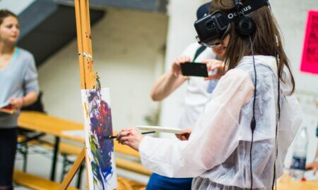 photo of young woman wearing a vr headset and painting on an easel